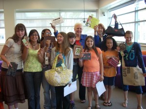 Students holding items for sale at Creative Women of the World
